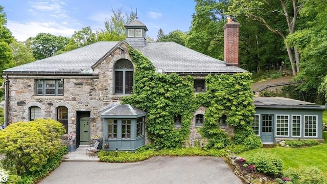 74 Warren St, Newton, MA 02459 - tudor-style house with a chimney, stone siding, and a high end roof
