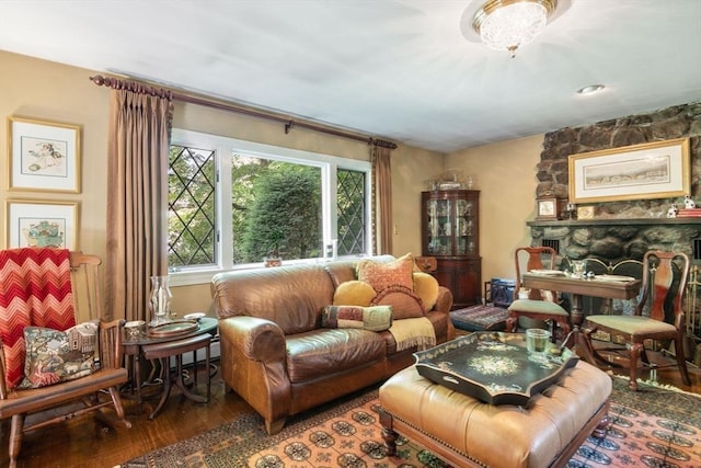 living area with hardwood / wood-style flooring and a stone fireplace