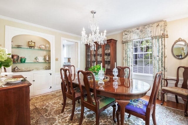 dining space featuring a notable chandelier, built in shelves, crown molding, and dark hardwood / wood-style flooring