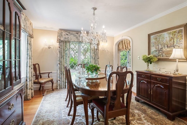 dining area featuring light hardwood / wood-style floors, a chandelier, and ornamental molding