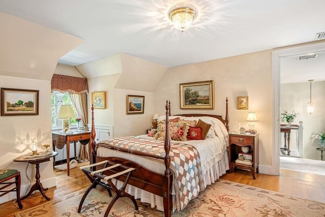 bedroom featuring light wood-type flooring and lofted ceiling