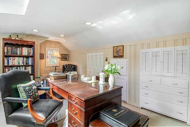 carpeted home office with lofted ceiling and wooden walls