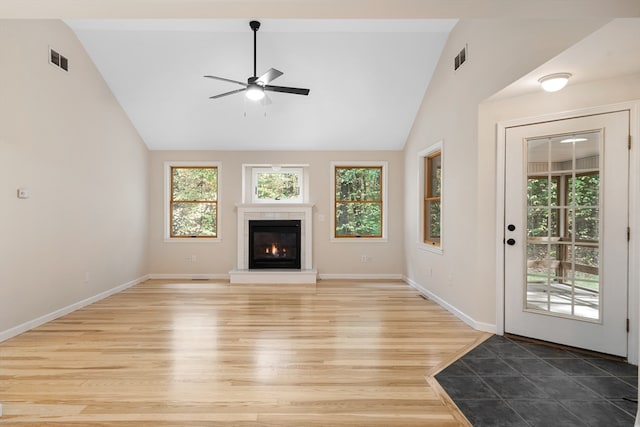 unfurnished living room featuring high vaulted ceiling, light hardwood / wood-style floors, and ceiling fan