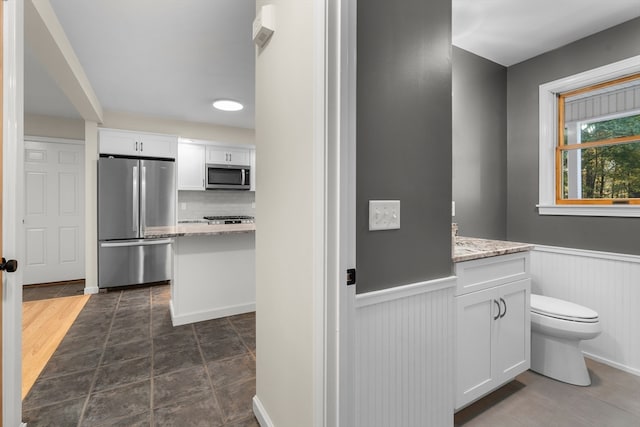 bathroom featuring decorative backsplash, hardwood / wood-style floors, vanity, and toilet