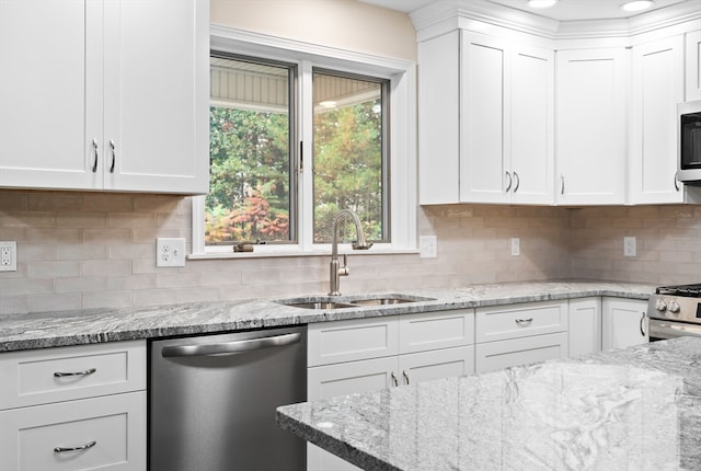 kitchen with white cabinets, appliances with stainless steel finishes, backsplash, and sink