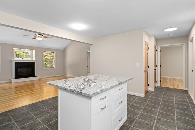 kitchen with a kitchen island, dark hardwood / wood-style flooring, ceiling fan, and white cabinets