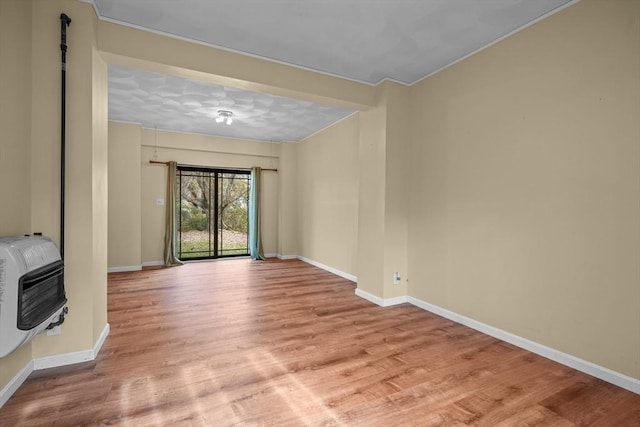 unfurnished living room with heating unit and light hardwood / wood-style flooring