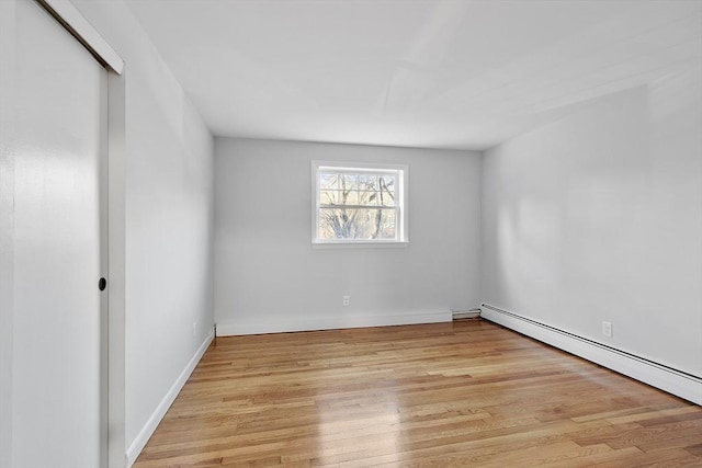 spare room with light hardwood / wood-style flooring and a baseboard heating unit