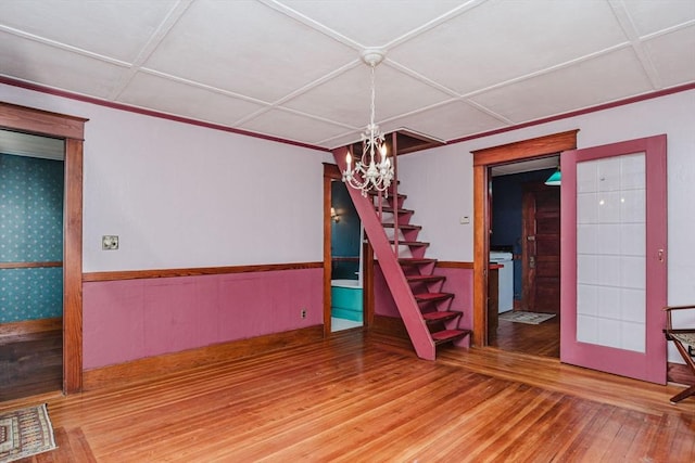 unfurnished room featuring hardwood / wood-style floors, coffered ceiling, and a notable chandelier