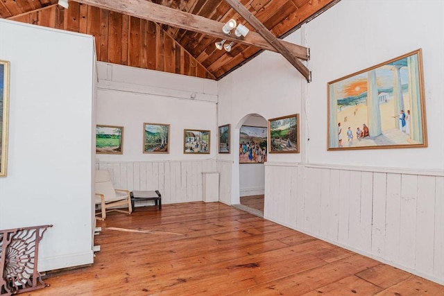 sitting room featuring beamed ceiling, wood-type flooring, high vaulted ceiling, and wooden ceiling