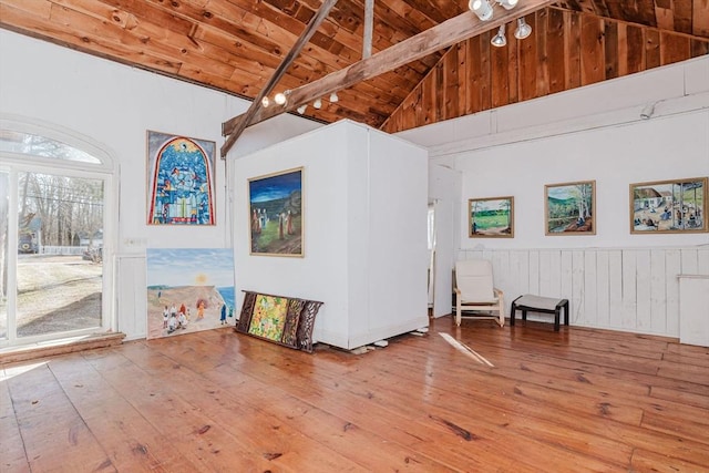 interior space with beam ceiling, high vaulted ceiling, wood ceiling, and hardwood / wood-style flooring