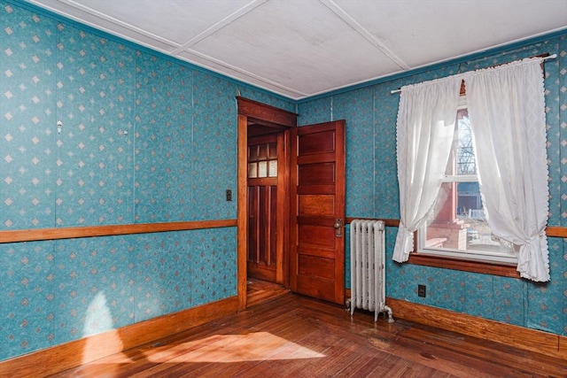 empty room featuring hardwood / wood-style flooring and radiator