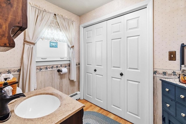 23 Fletcher St, Foxboro, MA 02035 - bathroom featuring wallpapered walls, a closet, baseboard heating, vanity, and wainscoting