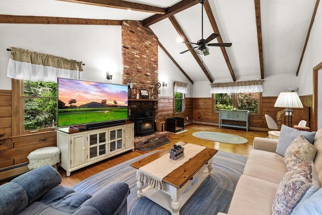 23 Fletcher St, Foxboro, MA 02035 - living room featuring a wainscoted wall, wooden walls, light wood-style floors, ceiling fan, and a wood stove