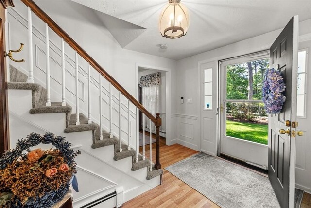 23 Fletcher St, Foxboro, MA 02035 - foyer with wood finished floors, stairway, baseboard heating, and a wainscoted wall
