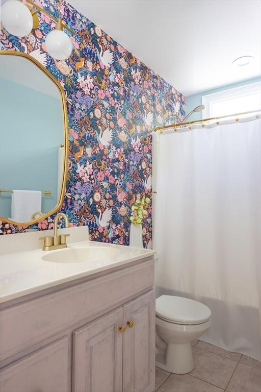 17-19 Beech Gln, Boston, MA 02119 - full bathroom with wallpapered walls, tile patterned flooring, vanity, toilet, and shower / bath combo