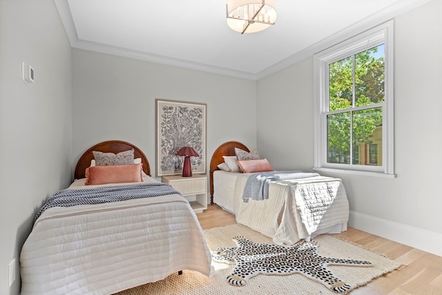 bedroom featuring ornamental molding and light wood-type flooring