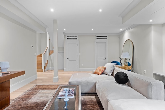 living room with crown molding and light hardwood / wood-style flooring