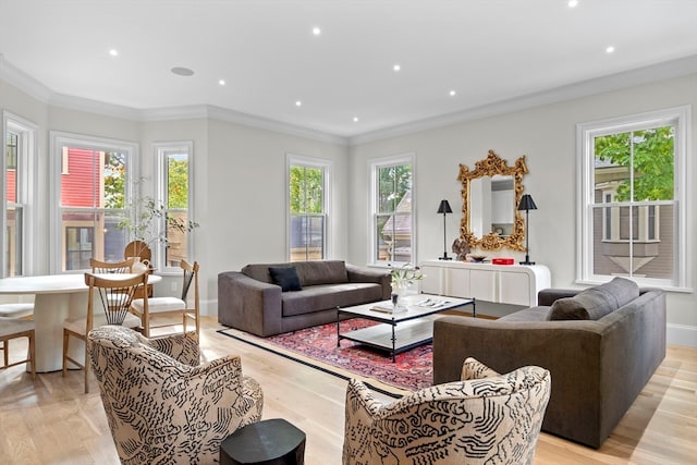 living room featuring crown molding, light hardwood / wood-style flooring, and a wealth of natural light