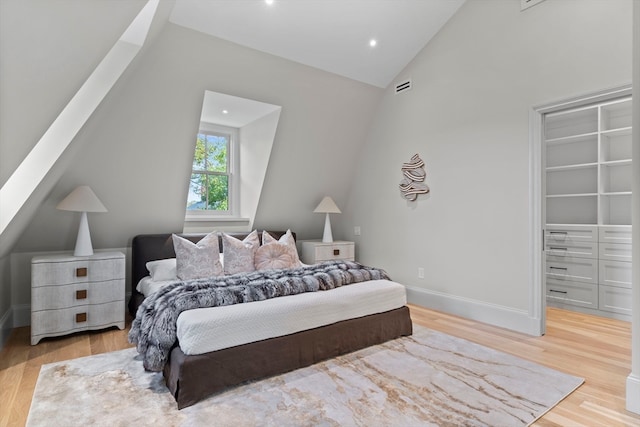 bedroom with lofted ceiling and light hardwood / wood-style flooring