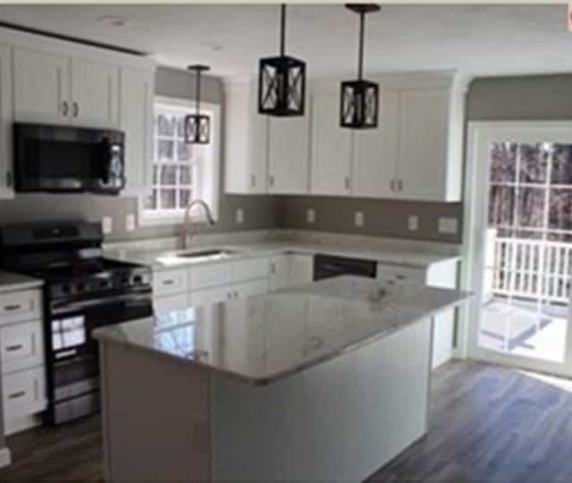 kitchen featuring stainless steel range, hanging light fixtures, a center island, white cabinets, and dark hardwood / wood-style flooring