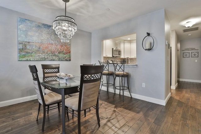 dining room with a chandelier, dark wood-style flooring, visible vents, and baseboards