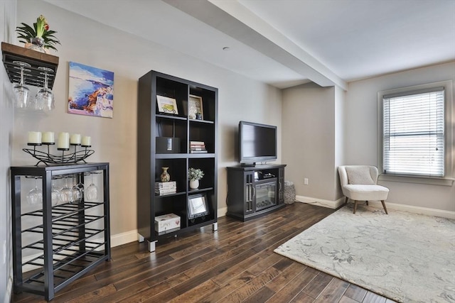 sitting room with a glass covered fireplace, dark wood finished floors, and baseboards