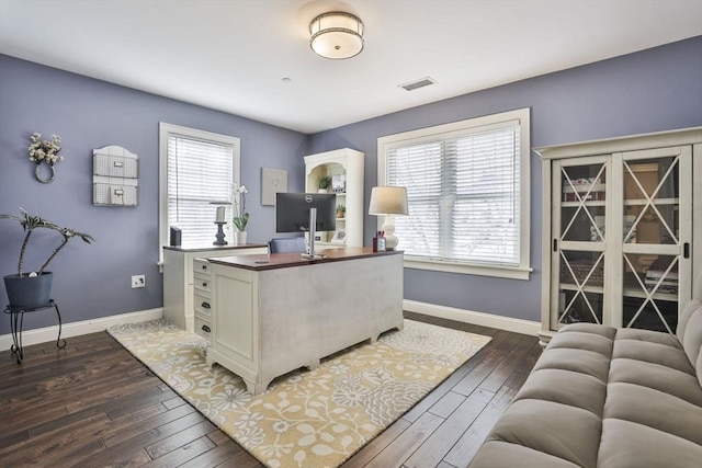 office area featuring plenty of natural light, dark wood finished floors, visible vents, and baseboards