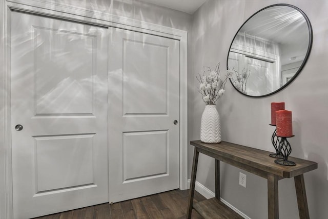 interior space featuring baseboards and dark wood-style flooring