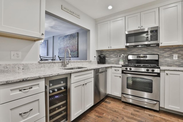 kitchen featuring wine cooler, a sink, white cabinetry, appliances with stainless steel finishes, and dark wood-style floors