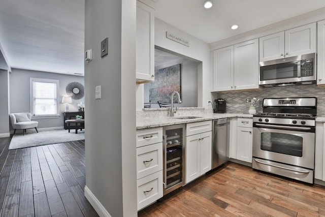 kitchen featuring tasteful backsplash, appliances with stainless steel finishes, dark wood finished floors, and a sink