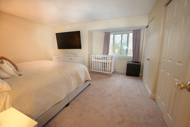 bedroom featuring light carpet and baseboards