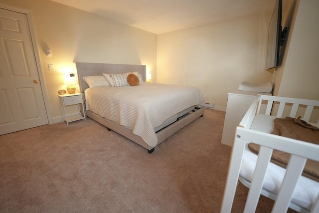 bedroom featuring light colored carpet and baseboards