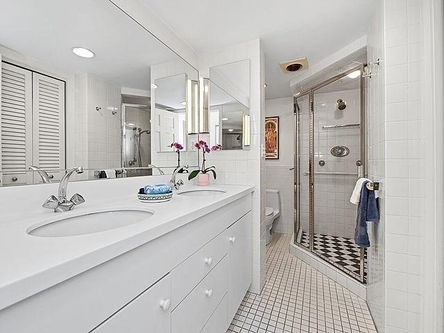 2 Hawthorne Pl Unit 2E & 2F, Boston, MA 02114 - bathroom with tile patterned floors, toilet, double vanity, a stall shower, and tile walls