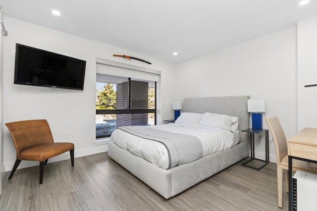 bedroom with recessed lighting, baseboards, and wood finished floors