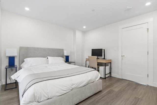 bedroom with recessed lighting, baseboards, and wood finished floors