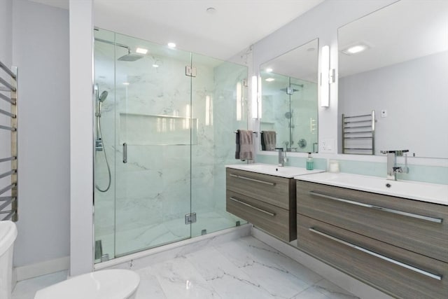 bathroom with radiator, two vanities, marble finish floor, a sink, and a marble finish shower