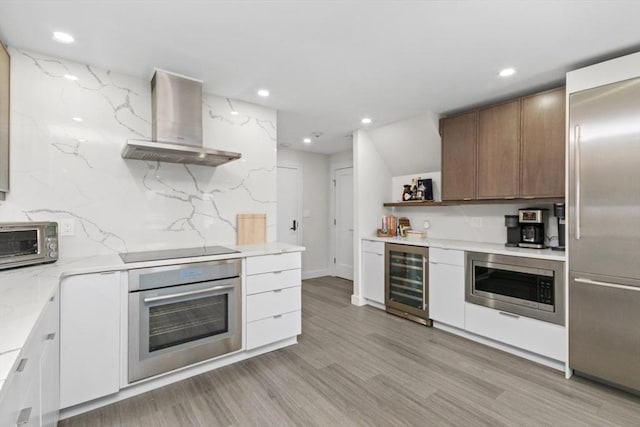 kitchen featuring light wood-style floors, wall chimney range hood, open shelves, wine cooler, and built in appliances