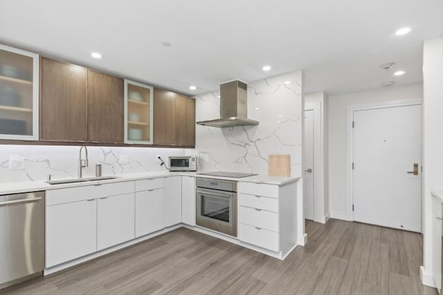 kitchen featuring light countertops, backsplash, extractor fan, stainless steel appliances, and a sink