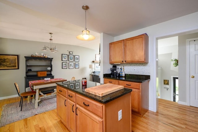 89 Block St, Abington, MA 02351 - kitchen featuring light wood-type flooring, a kitchen island, decorative light fixtures, vaulted ceiling, and brown cabinetry