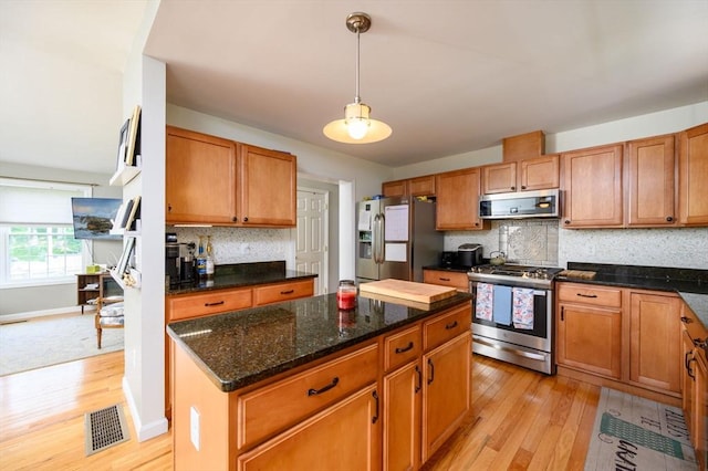 89 Block St, Abington, MA 02351 - kitchen with stainless steel appliances, light wood finished floors, backsplash, and a kitchen island