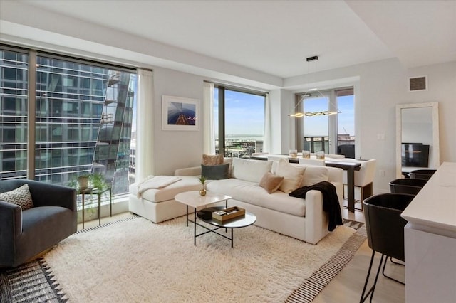 living area with visible vents and wood finished floors