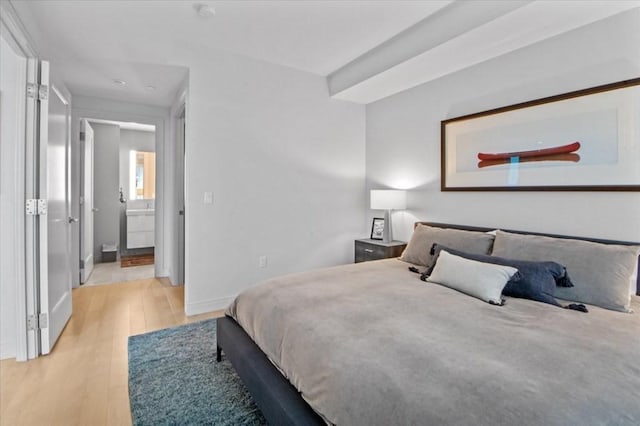 bedroom featuring baseboards and light wood finished floors