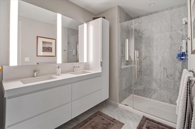 full bathroom with a marble finish shower, marble finish floor, double vanity, and a sink