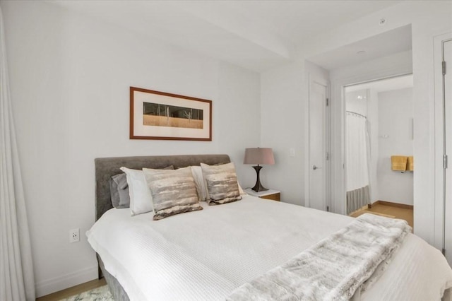 bedroom featuring baseboards and wood finished floors