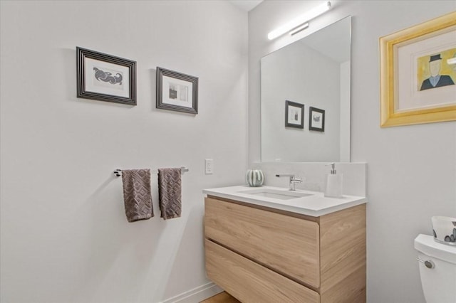 half bathroom featuring toilet and vanity