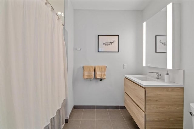 full bath featuring tile patterned floors, toilet, vanity, and baseboards