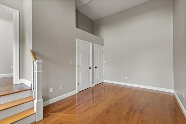 interior space with a high ceiling and hardwood / wood-style flooring