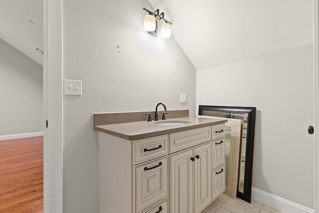 bathroom featuring lofted ceiling, tile patterned flooring, and vanity