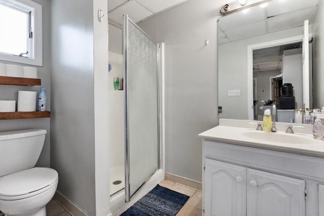 bathroom with a paneled ceiling, a shower stall, vanity, toilet, and tile patterned floors